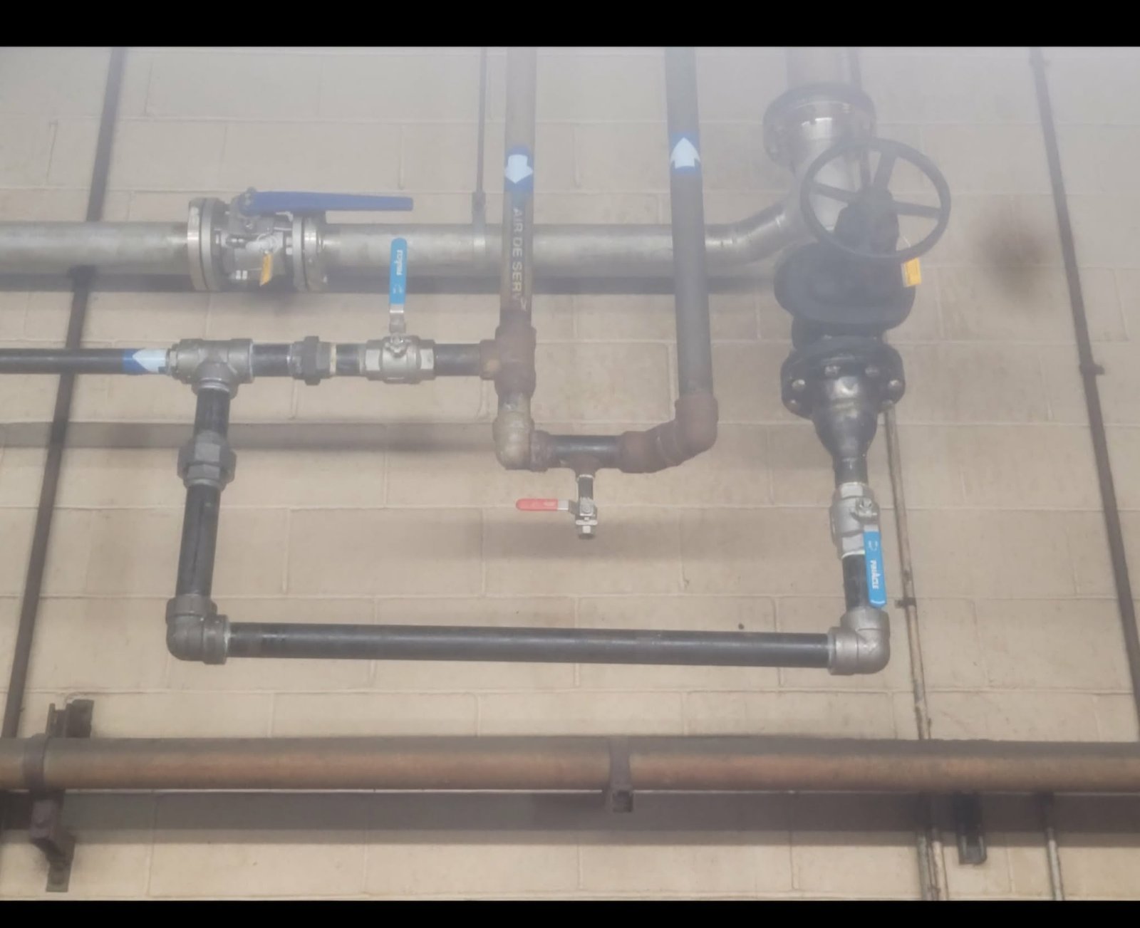 Réseau de tuyauterie industrielle installé au mur