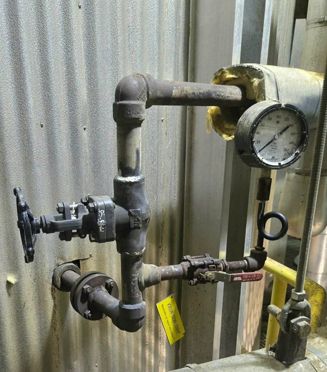 Tuyauterie industrielle reliée à un manomètre
